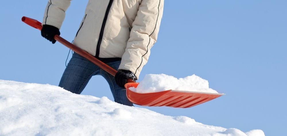 Individual shoveling a pile of snow.